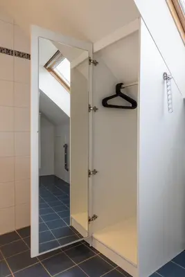 a dressing room with a mirror in a bathroom at Hotel & Apartments Bibois Leuven in Oud-Heverlee