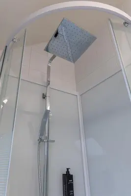 a shower with a shower head in a room at Hotel & Apartments Bibois Leuven in Oud-Heverlee