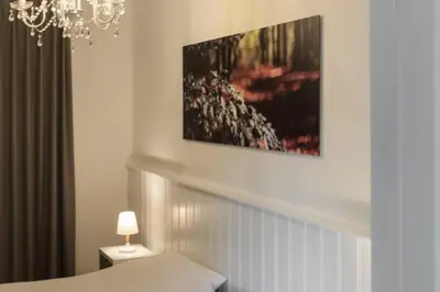 a room with a bed and a picture on the wall at B&B Gielse Garden in Gierle