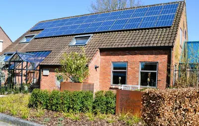 a house with solar panels on top of it at B&B Gielse Garden in Gierle