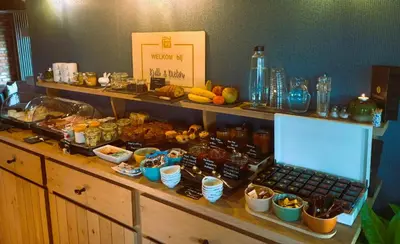 a buffet with a laptop on a counter with food at B&B Gielse Garden in Gierle