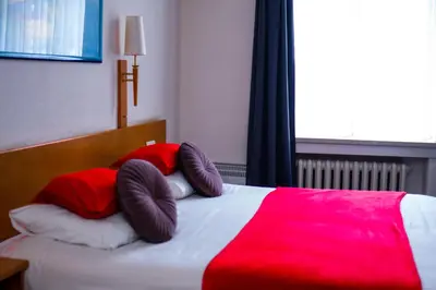 a bed with two pillows and a red blanket at Hotel Professor Leuven Centrum in Leuven