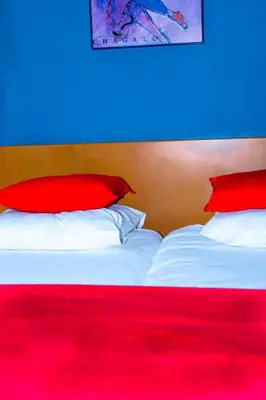 a bedroom with two red pillows on a bed at Hotel Professor Leuven Centrum in Leuven