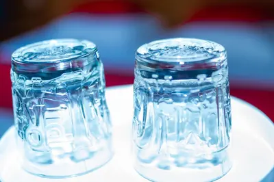 two glass mason jars sitting on a plate at Hotel Professor Leuven Centrum in Leuven