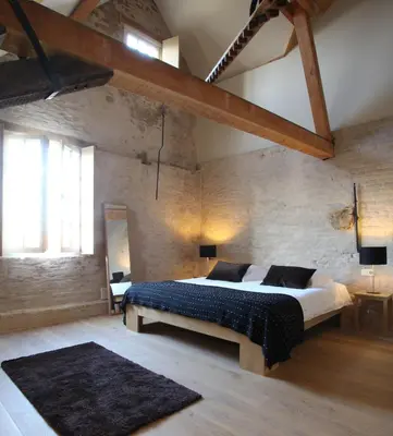 a bedroom with a large bed in a brick wall at 'S Hertogenmolens Hotel in Aarschot