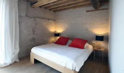 a bedroom with a bed with two red pillows at 'S Hertogenmolens Hotel in Aarschot