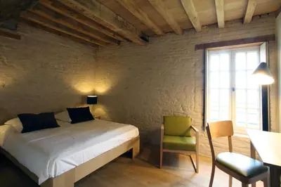 a bedroom with a bed and a table and a chair at 'S Hertogenmolens Hotel in Aarschot