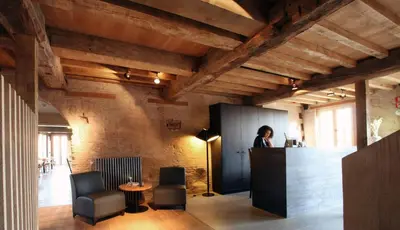 a woman standing at a counter in a room at 'S Hertogenmolens Hotel in Aarschot