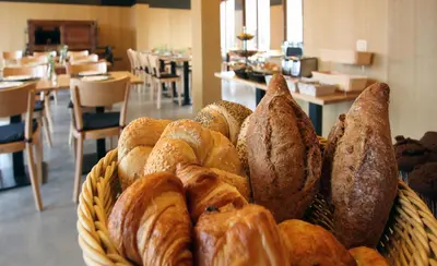 a basket filled with lots of different types of bread at 'S Hertogenmolens Hotel in Aarschot