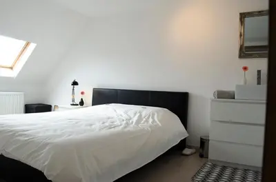 a bedroom with a white bed and a dresser at upstairs9000 in Ghent