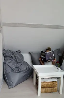 a person sitting on a bed reading a book at upstairs9000 in Ghent