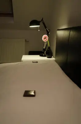 a bed with a lamp and a flower on it at upstairs9000 in Ghent
