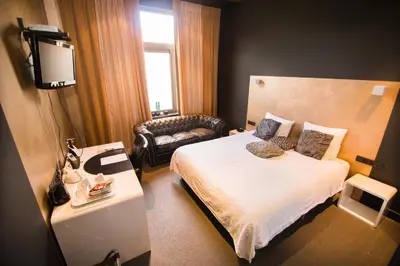 a hotel room with a bed and a couch at Hotel Moon in Sint-Niklaas