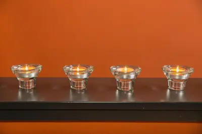 four candles are sitting on a black table at Hotel Moon in Sint-Niklaas