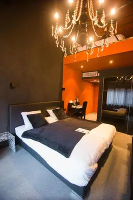 a large bed in a room with a chandelier at Hotel Moon in Sint-Niklaas