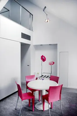 a dining room with a white table and pink chairs at Guesthouse PPP in Ghent