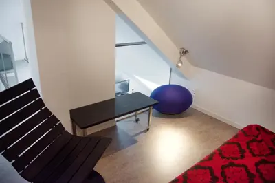 a living room with a chair and a table at Guesthouse PPP in Ghent