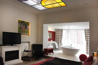 a living room with a tub and a television at Guesthouse PPP in Ghent