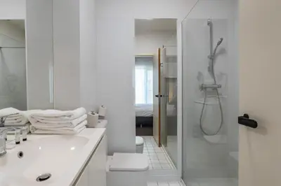 a white bathroom with a shower and a sink at Hobbit Hotel Brussels Airport Zaventem in Zaventem