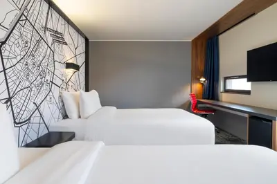 a hotel room with two beds and a tv at Pestana Brussels Schuman in Brussels