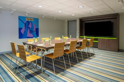 a conference room with a table and chairs and a screen at Pestana Brussels Schuman in Brussels