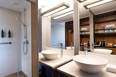 a bathroom with two sinks and a shower at Pestana Brussels Schuman in Brussels