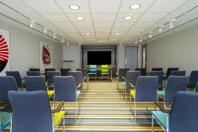 a conference room with chairs and a projection screen at Pestana Brussels Schuman in Brussels