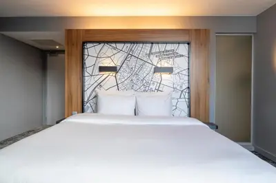 a bedroom with a large bed with a stained glass window at Pestana Brussels Schuman in Brussels