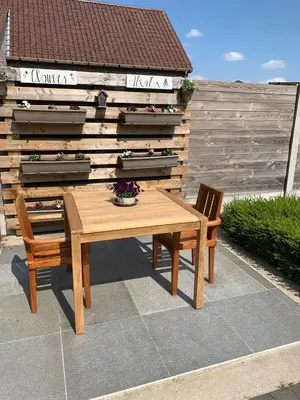 a wooden table and two chairs on a patio at Q Studio in Herzele