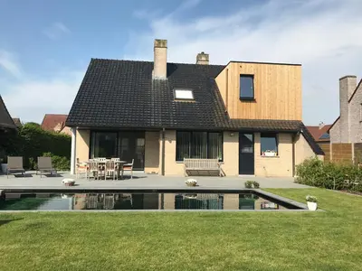 a house with a swimming pool in the yard at Q Studio in Herzele