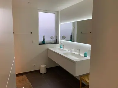 a white bathroom with a sink and a mirror at Q Studio in Herzele