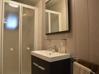 a bathroom with a sink and a shower at Modern waterfront chalet in Geel