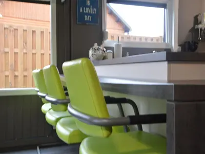 a row of green chairs sitting at a desk at Modern waterfront chalet in Geel