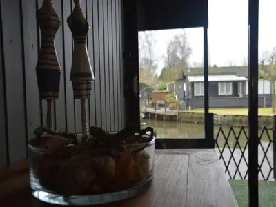 a bowl of food sitting on a table next to a window at Modern waterfront chalet in Geel