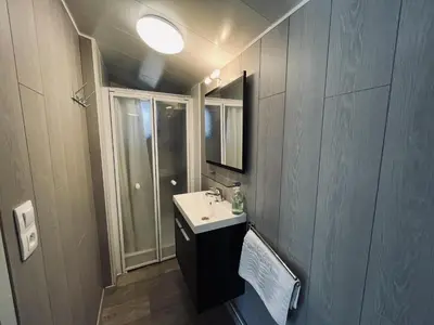 a small bathroom with a sink and a mirror at Modern waterfront chalet in Geel