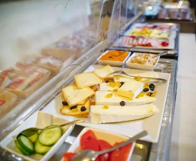 a display case with cheese and other food items at Hotel Otus in Wetteren