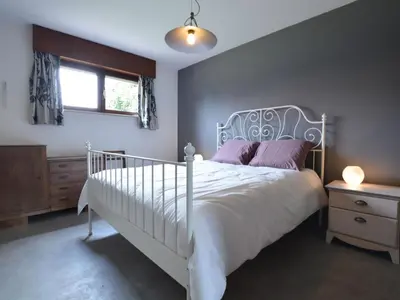 a bedroom with a white bed with purple pillows and a window at Lovely Holiday Home in Merksplas with Fenced Garden in Merksplas