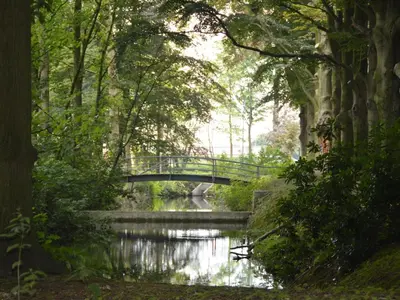 a bridge over a river in a park at Lovely Holiday Home in Merksplas with Fenced Garden in Merksplas