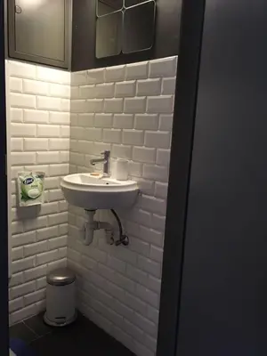 a bathroom with a sink and a white brick wall at Gachard in Brussels