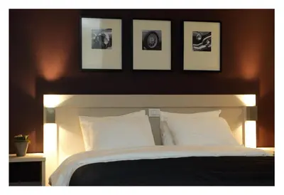 a bedroom with a large bed with four pictures above it at Hotel Florent in Lier