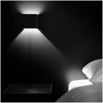 a black and white photo of a bed with a light at Hotel Florent in Lier