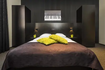 a bedroom with a large bed with yellow flowers on it at Hotel Florent in Lier