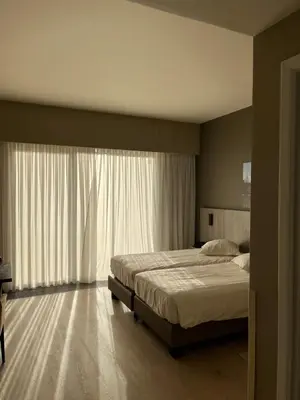 a bedroom with a bed and a large window at Hotel In den Bonten Os in Rijmenam
