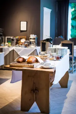 a table with a loaf of bread on top of it at Hotel In den Bonten Os in Rijmenam