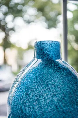 a blue glass vase sitting in front of a window at Hotel In den Bonten Os in Rijmenam