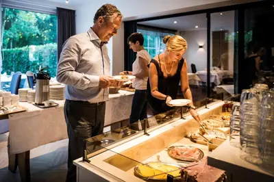 a man and a woman holding plates of food at Hotel In den Bonten Os in Rijmenam