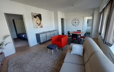a living room with a couch and a red chair at Astrid - apartments in Mechelen