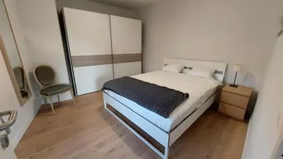 a small bedroom with a bed and a chair at Astrid - apartments in Mechelen
