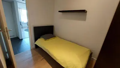 a small bedroom with a yellow bed in a room at Astrid - apartments in Mechelen