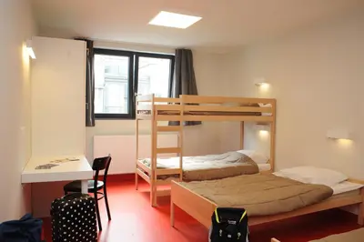a room with two bunk beds and a desk at Hostel Bruegel in Brussels